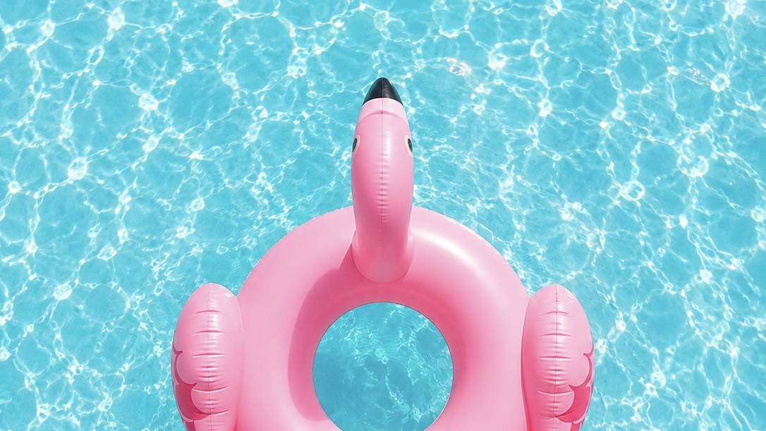 Pink flamingo pool float in turquoise water